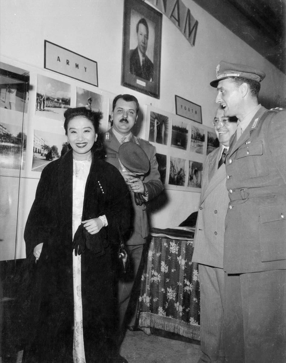 Madame Hoa Ly with Italian officers beneath a framed portrait at the Vietnam pavilion